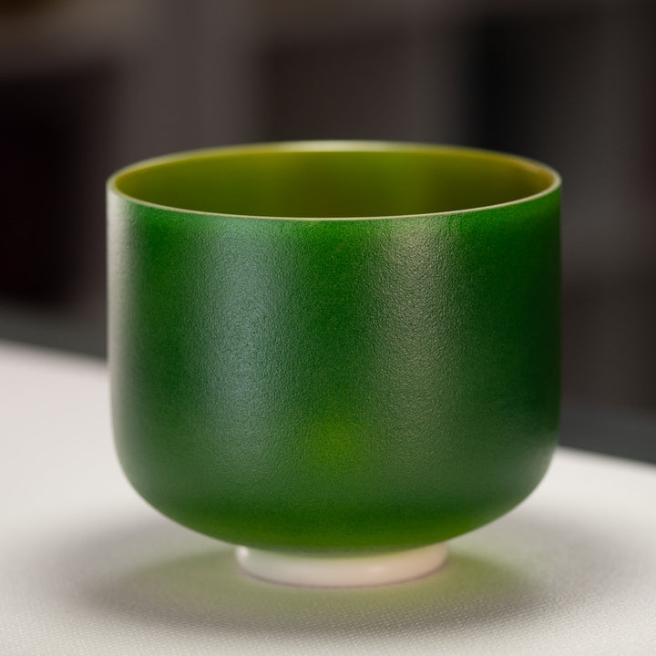 A 9-inch frosted green crystal singing bowl with a gold interior, placed on a white surface.