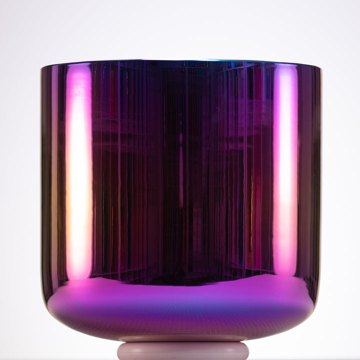 Vibrant purple crystal singing bowl with a reflective surface on a white background