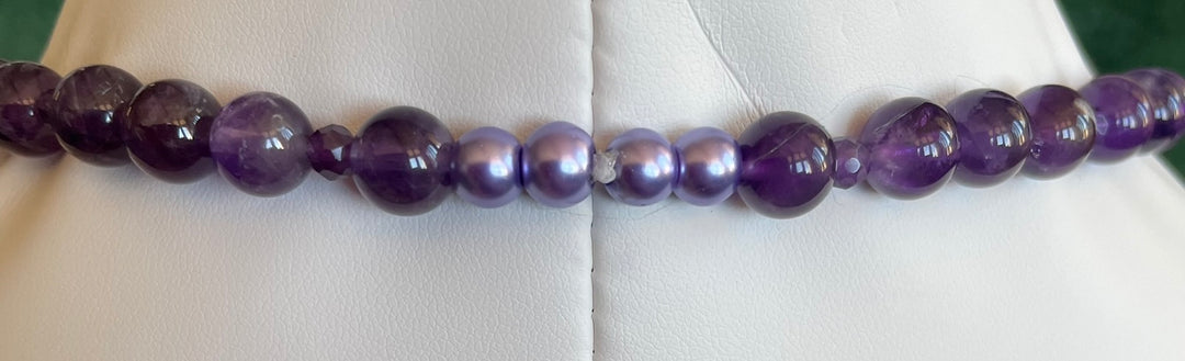 Purple beaded necklace on a white background