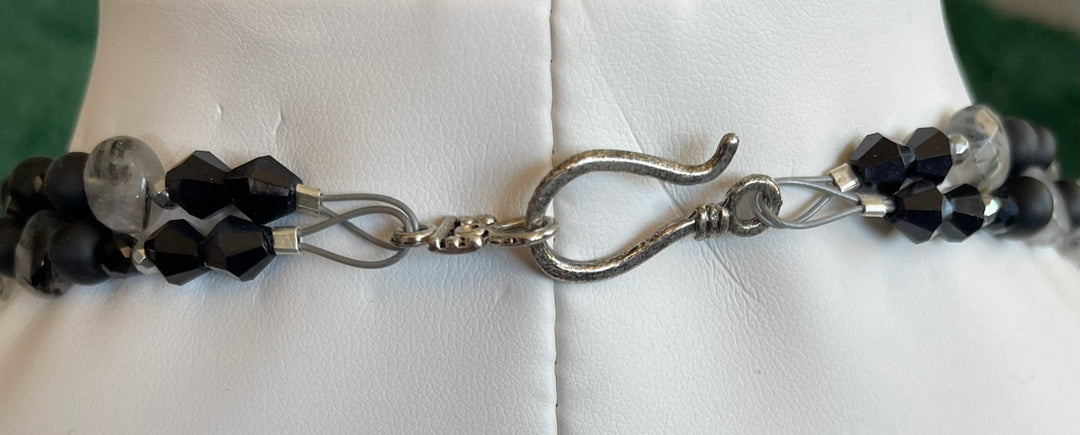 Necklace with black and clear beads and silver hook clasp on a white background